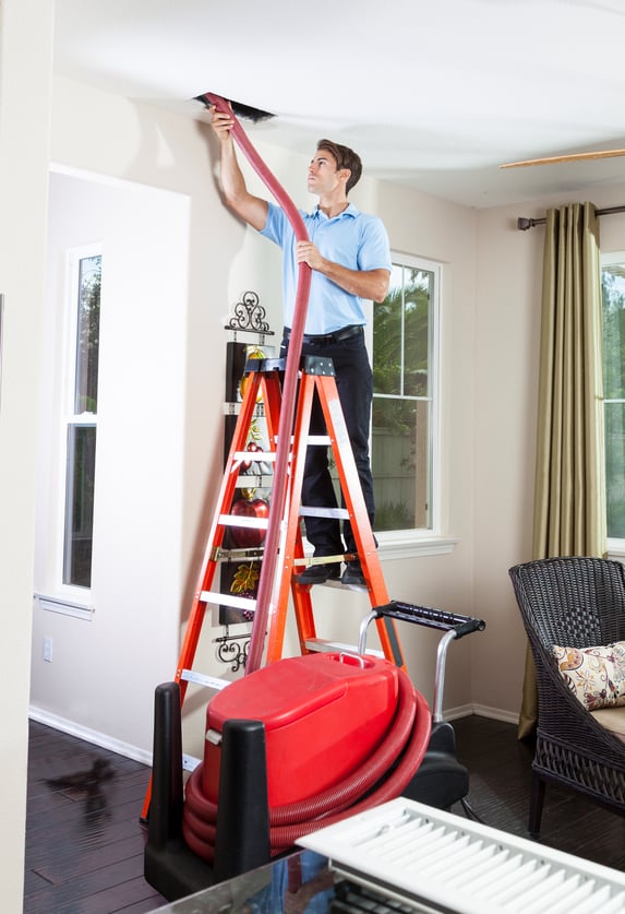 Man cleaning air ducts in home.